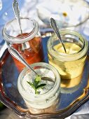 Assorted dips in glass jars with spoons