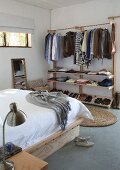 Kleiderständer mit Ablagen in schlichtem Schlafzimmer
