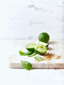Limetten, brauner Zucker & Minzeblättchen als Zutaten für Mojito