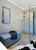 Concrete floor and marbled wall in purist bathroom with walk-in shower and upholstered bench