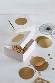 Hand-crafted cardboard boxes for storing punched gold confetti