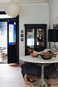 Bowls on marble bistro table with cast iron pedestal base in front of black display case