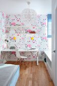 Desk, classic chair and floral wallpaper in narrow teenager's bedroom