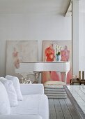 Sofa mit weisser Husse und Klavier in offenem Wohnbereich mit geweisselter Ziegelwand, moderne Gemälde