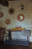 Round mirrors with basketwork frames hung on stone wall