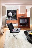 Living area with leather armchairs and glossy table on rug and TV cabinet with exotic wood fronts