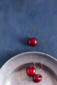 Sweet cherries on a pewter plater sprinkled with sugar