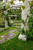 Antique columns lining path and steps leading to stone bench in seating area