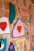 Stone wall covered in colourful hippie-style artworks