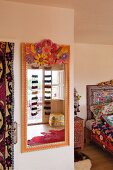 Ethnic-style bedroom with brightly painted mirror and patterned bed