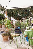 Green metal chairs below pavilion on Mediterranean terrace