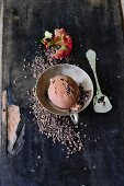 A scoop of chocolate ice cream with cocoa nibs