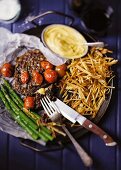 Beefsteak with Bearnaise sauce, green asparagus and potatoes straw