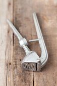 A garlic press on a wooden surface