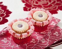 Cupcakes decorated with jam sandwich biscuits and jelly sweets