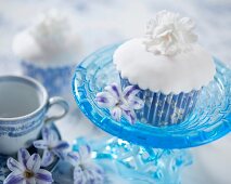 A white cupcake with a fondant flower