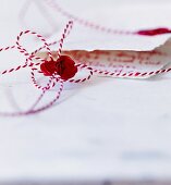 Schleife aus rot-weißem Bäckergarn mit Siegelwachs und Notenschlüssel als Siegel