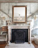 Antique fireplace with chandelier sconces on opulent mirrored wall