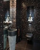 Guest toilet with elegant, shimmering, brown and black mosaic tiles, Buddha figurine and pedestal sink