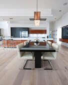 Black dining table and cantilever chairs in open-plan kitchen-dining area