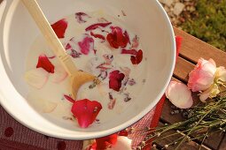 Milk and petals in bowl for making milk-based beauty treatment