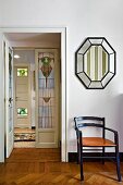 Chair below mirror; view of interior door with art nouveau glass panels in hallway