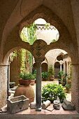 Blick durch Arkaden in Innenhof der italienischen Villa Cimbrone, auf Boden Pflanzentöpfe