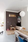 Play area with chalkboard wall on wooden platform with drawer below; dining table in foreground