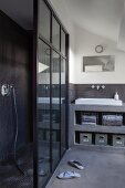 Grey bathroom with separate shower area and open-fronted concrete shelves with integrated sink