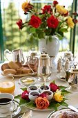 Gedeckter Frühstückstisch mit Marmeladen in Schälchen und Silberkannen, im Hintergrund Blumenstrauss (Villa Cimbrone Hotel)