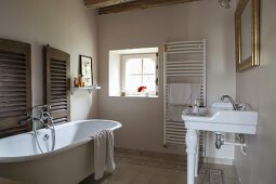 Freistehende Vintage Badewanne und Waschbecken auf Beinen aus Porzellan in ländlichem Bad