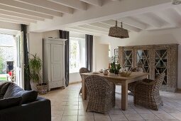 Wicker furniture in open-plan living-dining area of renovated farmhouse