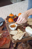 A cheese platter with chutney and crackers for a picnic-style Christmas meal