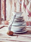 Still-life arrangement of crockery, fork and potato