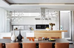 View across dining table with leather chairs into kitchen