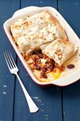 Enchiladas stuffed with beef, tomatoes and kidney beans topped with feta cheese