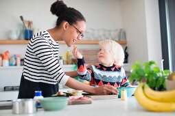 Kind füttert Mutter mit Obst