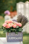 Rosen und getrockneter Lavendel in lilafarbenem bedrucktem Vintage-Holzkistchen