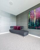 Curved sofa with dark grey cover in corner against wall with striped grey and brown wallpaper