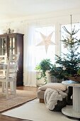 Schlicht geschmückter Weihnachtsbaum neben Kabelrolle und Esstisch