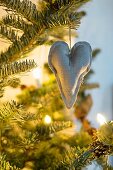 Linen heart hanging from illuminated Christmas tree