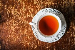 Eine Tasse Tee auf Holzuntergrund (Draufsicht)