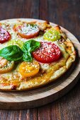 A tomato, cheese and basil pizza