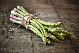 A bunch of green asparagus on a wooden board