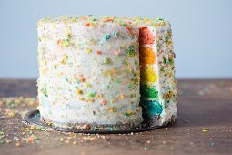 A rainbow layer cake with white frosting