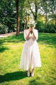 A bride holding her bouquet in front of her face