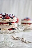 Hazelnut pavlova with fresh berries, cream and berry sauce