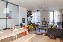 Wooden dining table and bench in front of various seating in lounge area