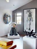 Exhibits and artworks on plinths and framed picture on grey wall