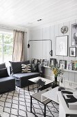 Set of coffee tables and grey easy chairs on patterned rug in white, wood-clad living room